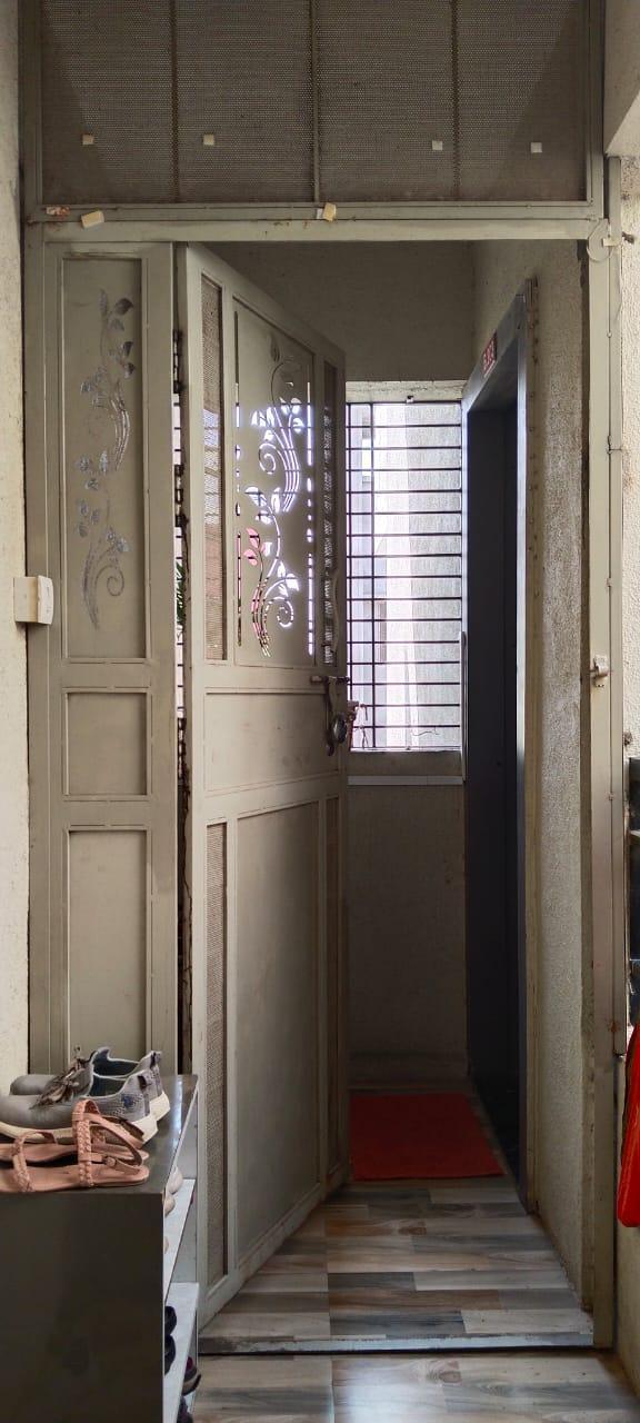 Entrance area showing a gray metal security door with grills and narrow corridor. (Source: CKA Archives)
