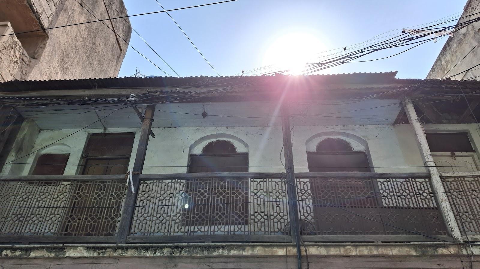 Exterior view of a historic residence in Ahilyanagar showing decorative balcony railings and arched openings on the upper floor. (Source: CKA Archives)