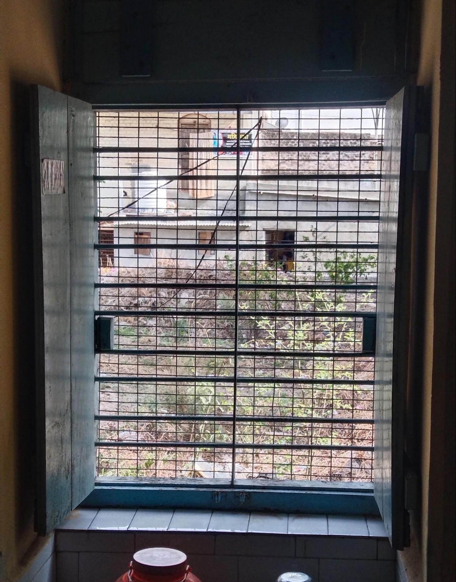 The windows have horizontal and very symmetrical iron grills that are overshadowed by the metal mesh, which was likely added later. (Source: CKA Archives)