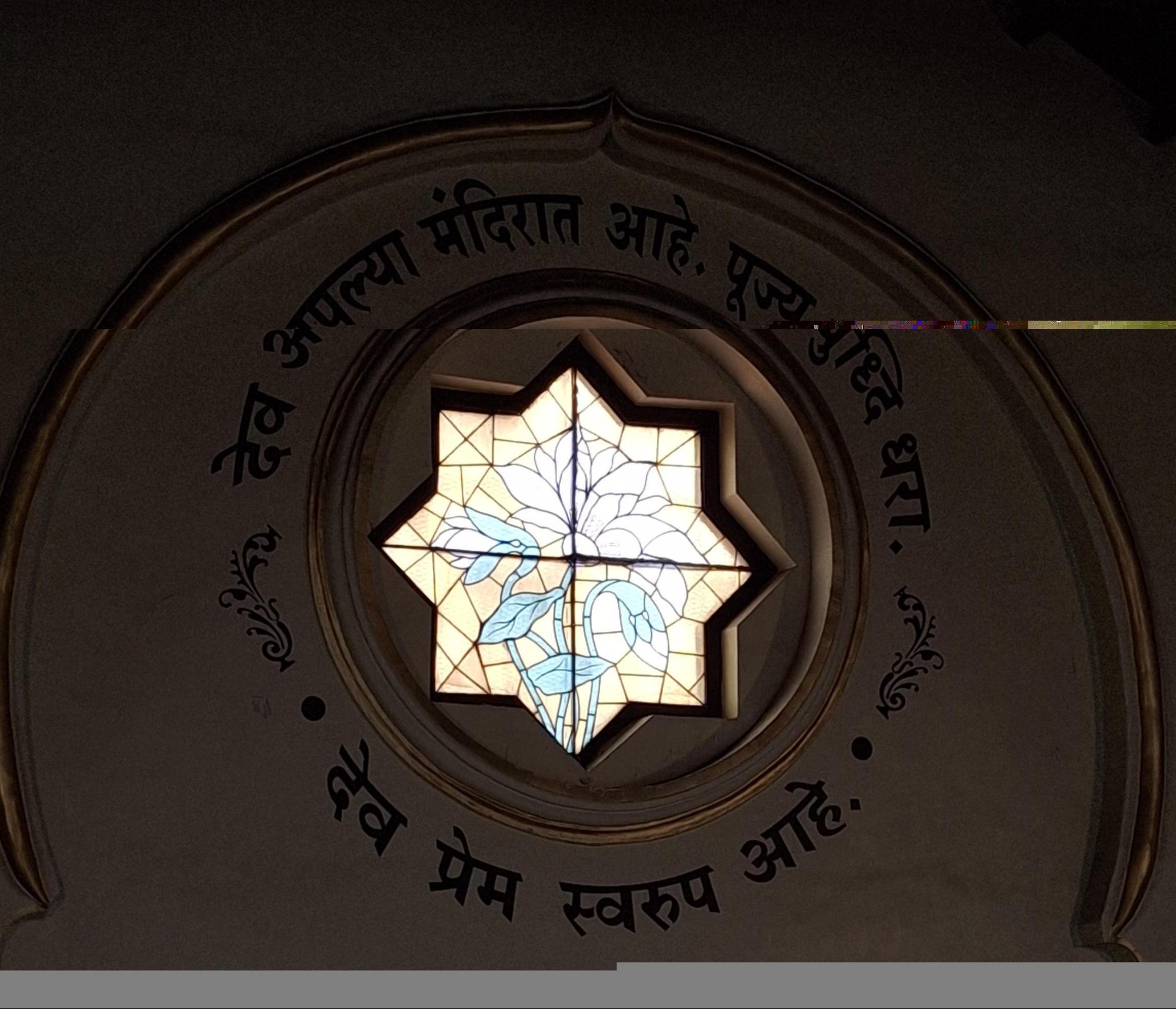 A detailed view of one of the Hume Memorial Church’s lotus flower stained glass windows, surrounded by a circular frame with Marathi text inscriptions. (Source: CKA Archives)