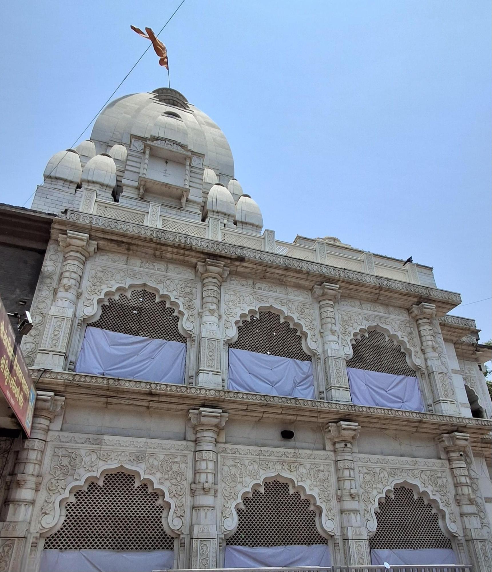 The exterior of the Vishal Ganpati Mandir of Ahilyanagar. Notice the traditional Maratha architectural elements, including ornate arched windows (jharokhas) and a domed shikhara. Note the distinctive white stone construction and decorative carved details. (Source: CKA Archives)