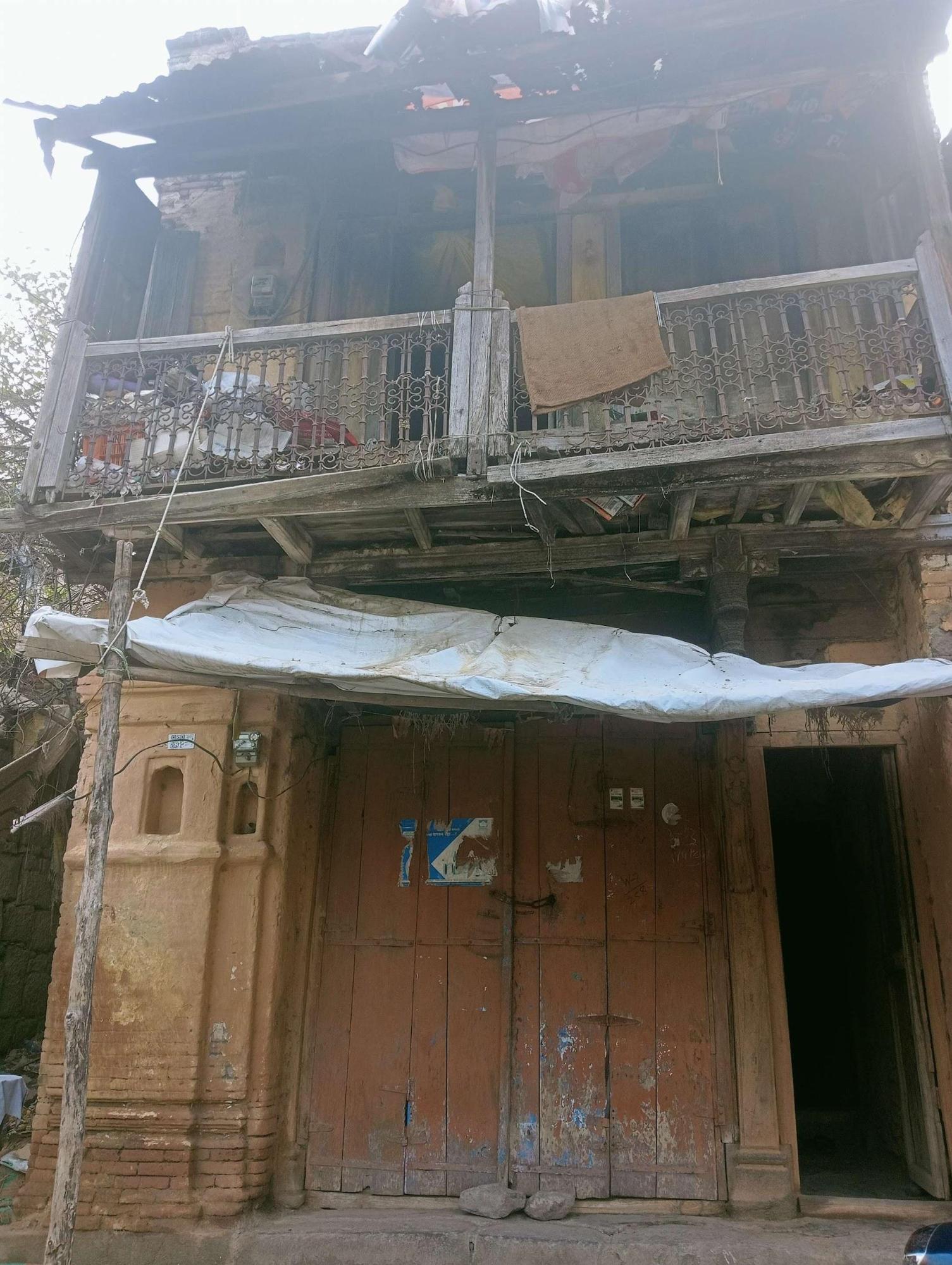 The large door of the house has a space where vegetable vendors sit and sell vegetables. The devlis on the left side of the door, provide much-needed light in the evenings for the vendors. (Source: CKA Archives)