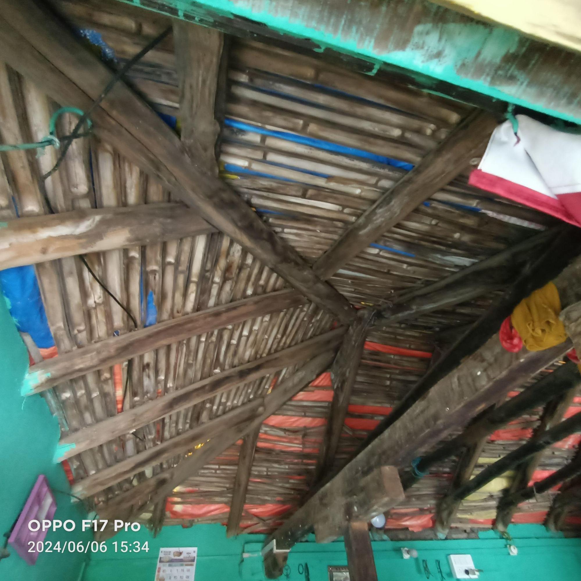 Exposed wooden rafters and battens supporting the roofing material, showing the traditional triangular roof framework against turquoise painted walls. (Source: CKA Archives)