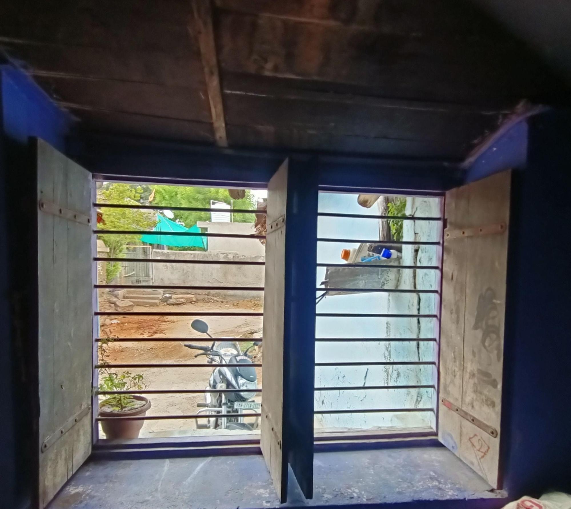 Similar window design viewed from the interior, showing metal grills against natural light. (Source: CKA Archives)