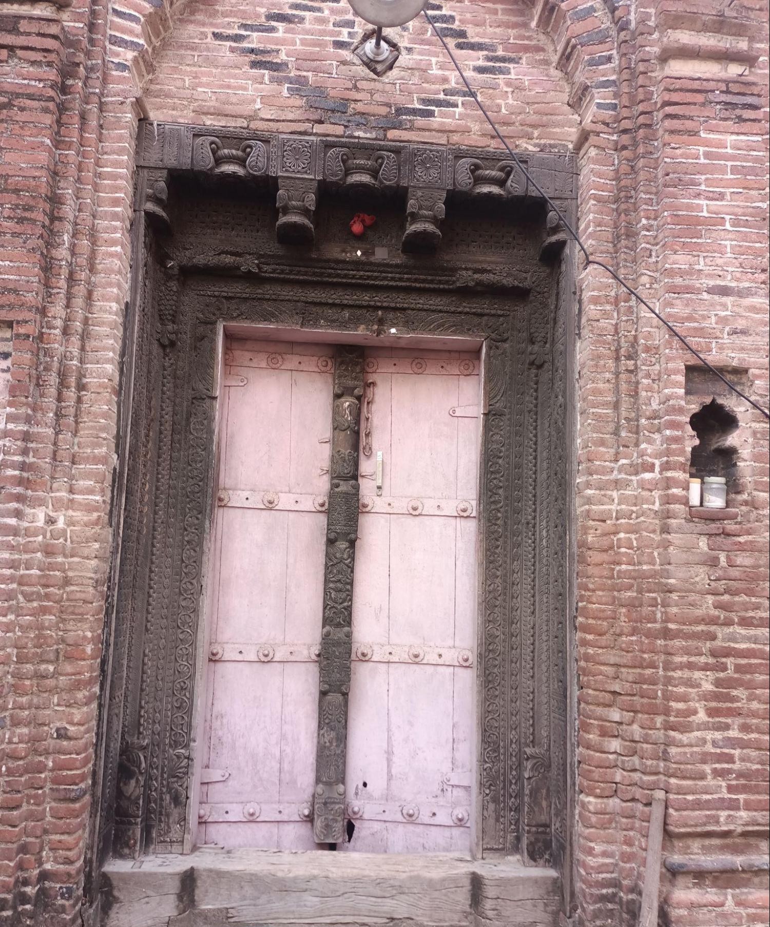 The double doors, with their borders, trims, and central divider, set the tone for the house's architectural character. (Source: CKA Archives)
