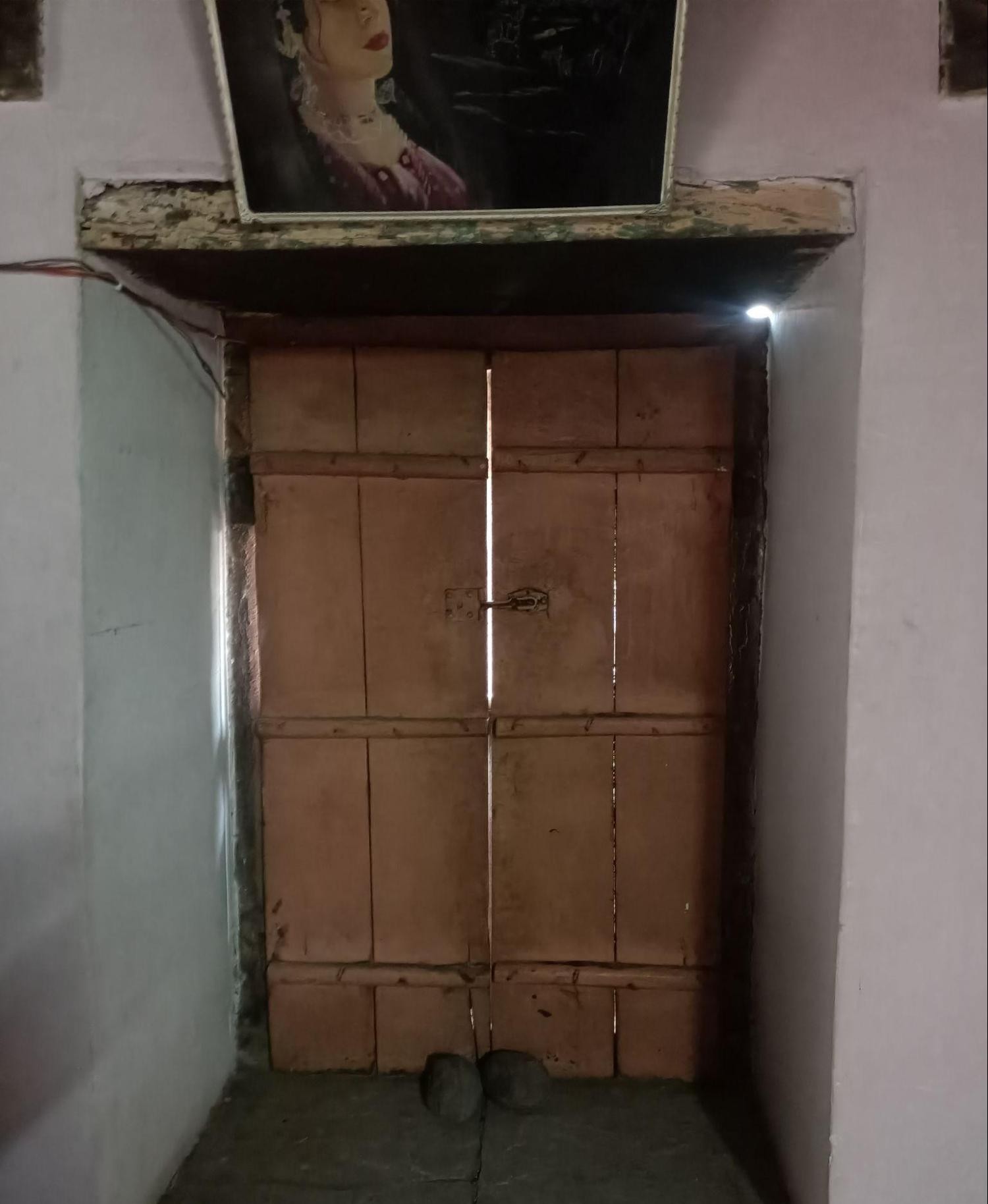 The wooden, double-doored window is separated by a sill, creating a clear boundary between the interior space and the window. (Source: CKA Archives)