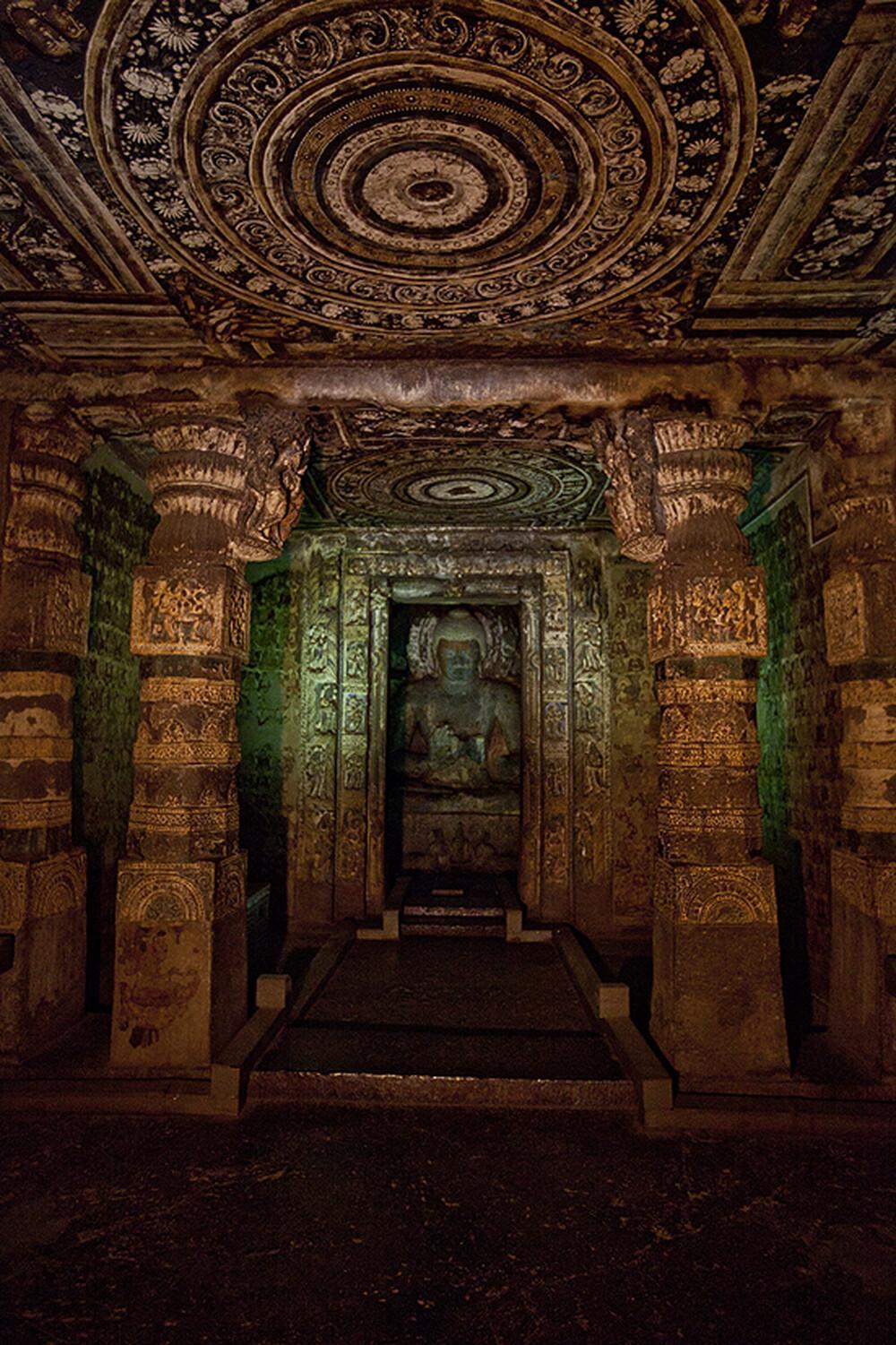 Another Murti of Buddha at Ajanta, notice the intricate carvings on the ceiling[3]