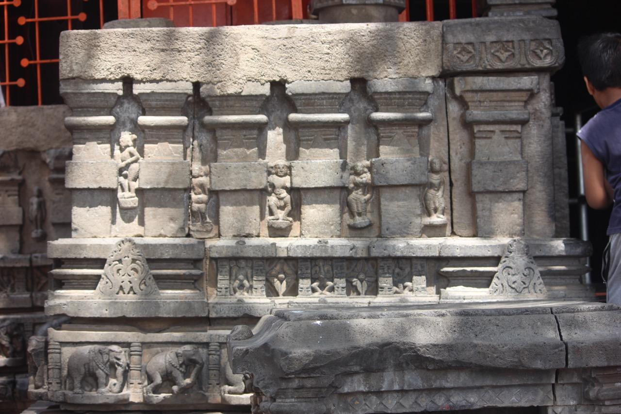 Carvings along the base of the Mandir walls, showing figures of devis and devtas alongside elephants.