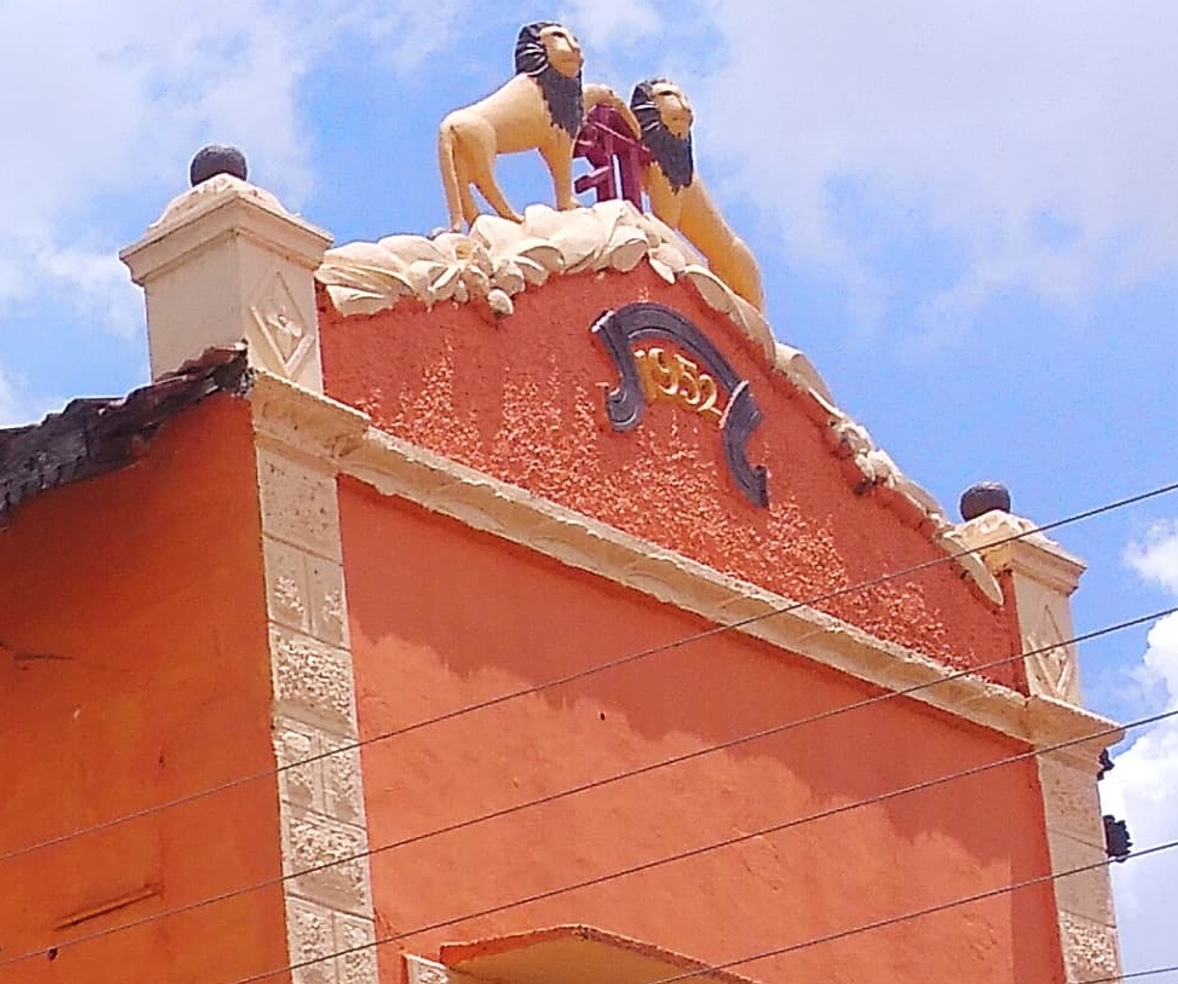 A close up of the upper portion of the facade of the house where one can see the date of its establishment. Alongside that, notice the unique pediment of the structure and the sculptures and engravings that sit above. At the center, two lion sculptures flank the letter 'Shri,' both of which hold immense religious and cultural significance. (Source: CKA Archives)