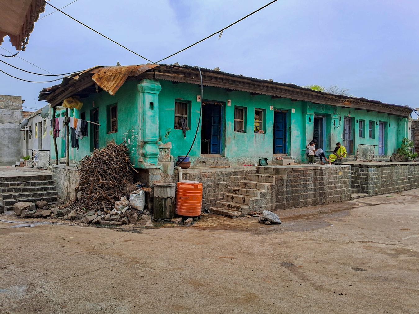 A single-storey house with striking turquoise walls and an elevated plinth on a street in Hingoli. Notice the staircases that connext it to the adjoining street. (Source: CKA Archives)