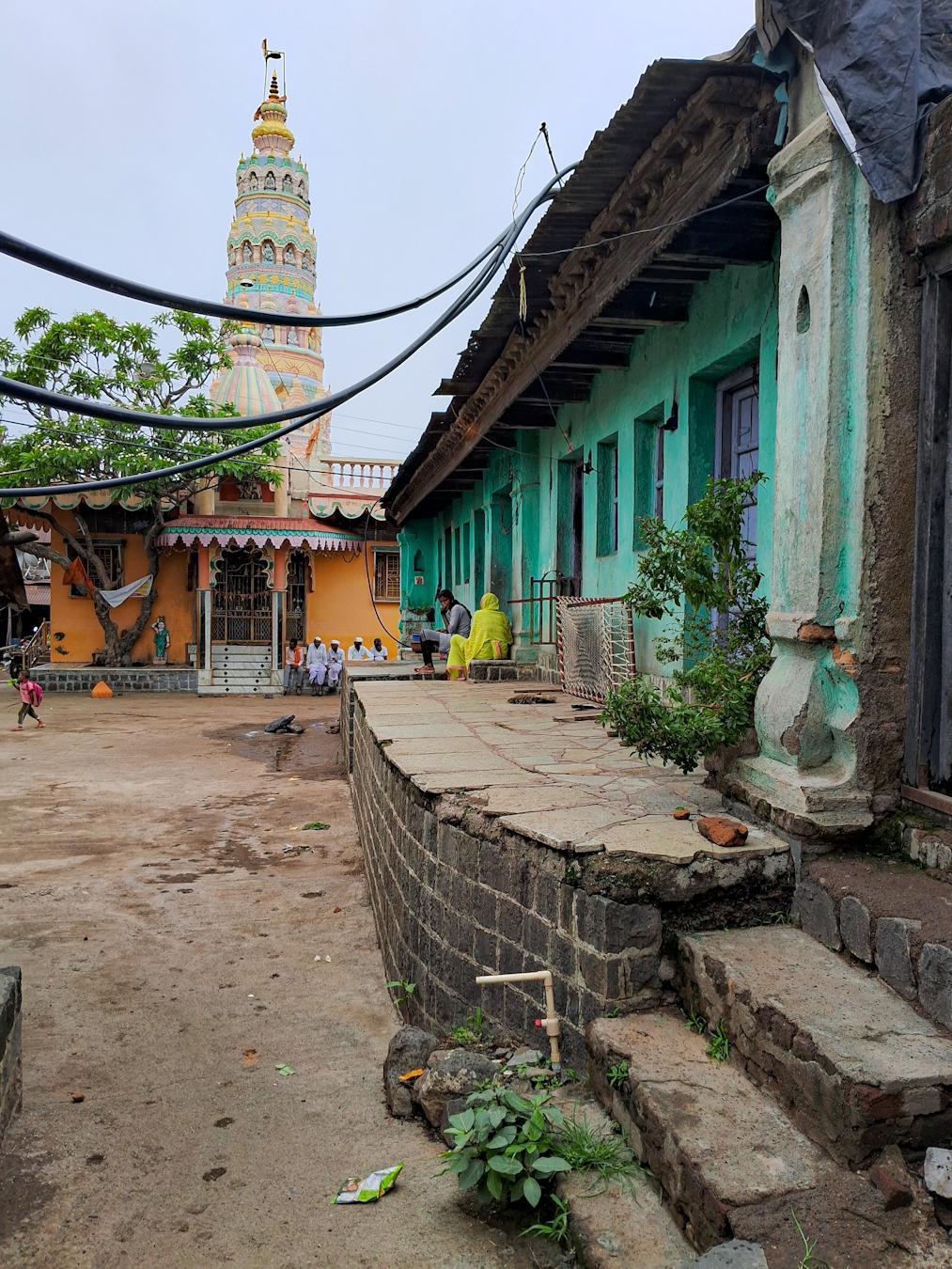 A view of the house featuring distinctive turquoise walls. The mandir, located at the far end of the street, is believed to be the oldest in the village. (Source: CKA Archives)