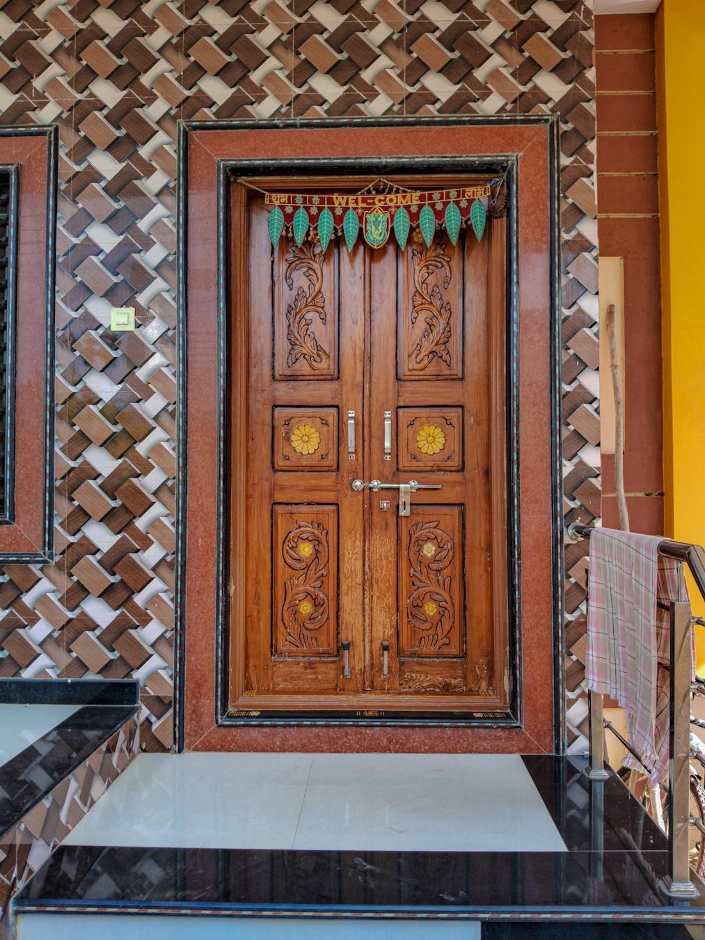 The main entrance door is wooden and double-shuttered. It has distinctive floral carvings on it. The tiles on the wall beside the door are of a unique style called Dholpuri. (Source: CKA Archives)