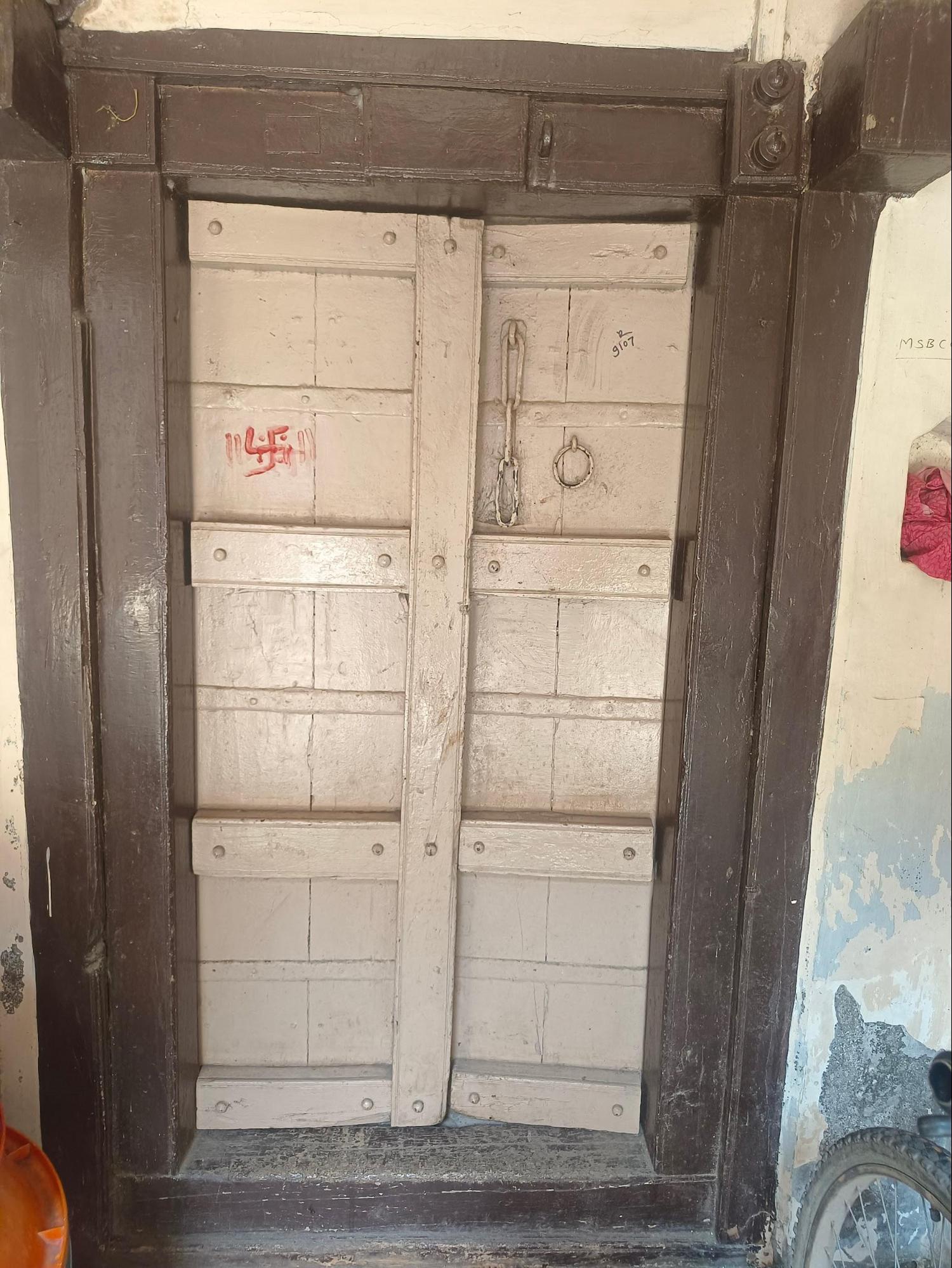 A Wooden double-leaf door embedded within a wooden frame. The craftsmanship highlights the design aesthetics typical of Wada architecture which seems to be fading away from contemporary building practices. (Source: CKA Archives)