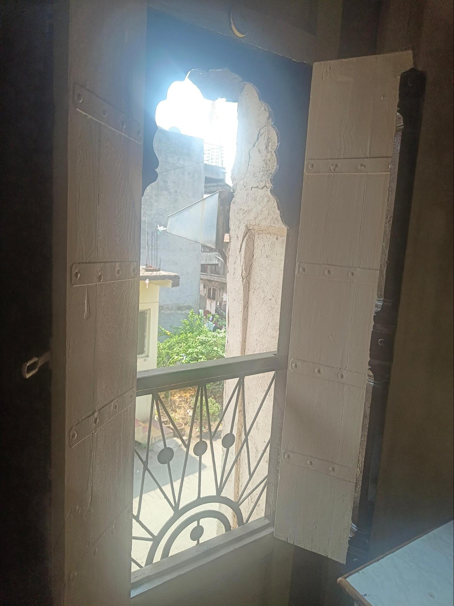 An interior view of a tall window at the facade of the upper storey, showcasing its arched top and railing at the bottom, which allows for airflow while maintaining security. (Source: CKA Archives)