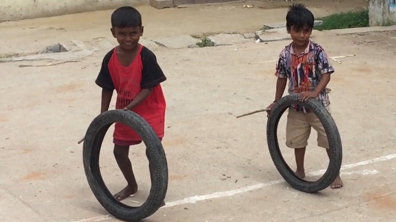 Children playing the Tire and Sticks Game, (Source: CKA Archives).