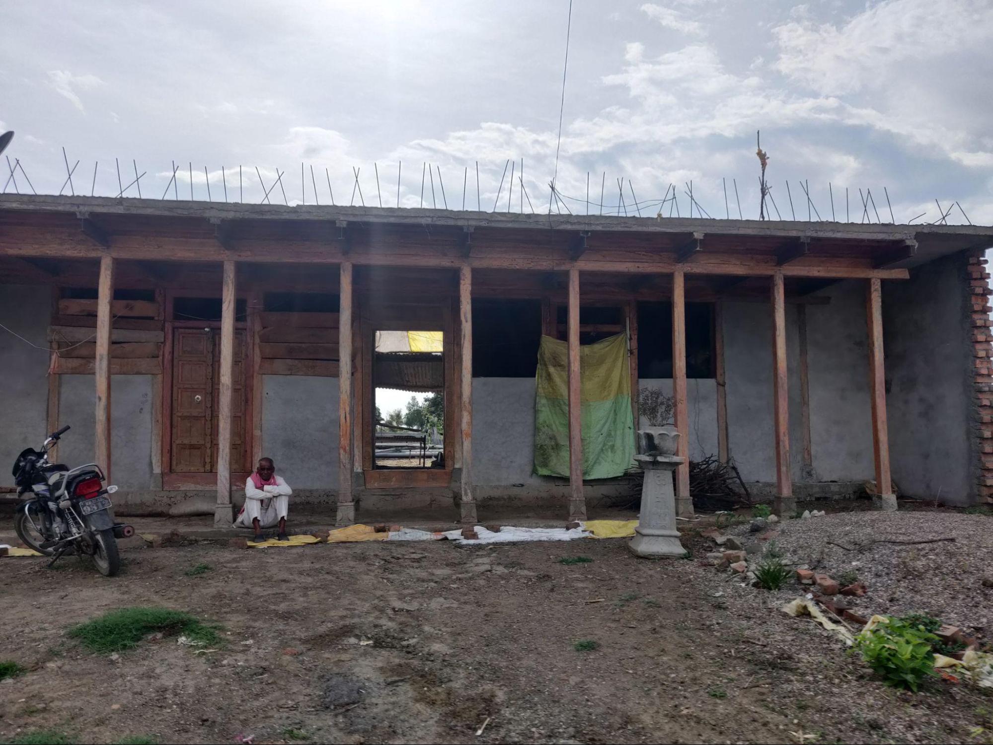 A newly built Malwad house under construction, showing exposed neem wood framework and unfinished cement layers. (Source: CKA Archives)