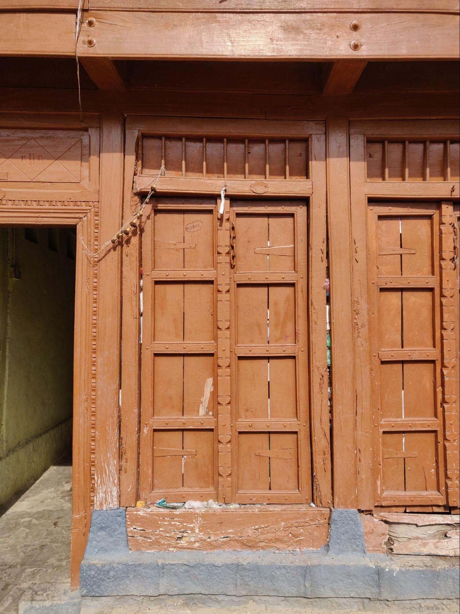 Main entrance door with double shutters, panel design, and a clerestory window above. (Source: CKA Archives)