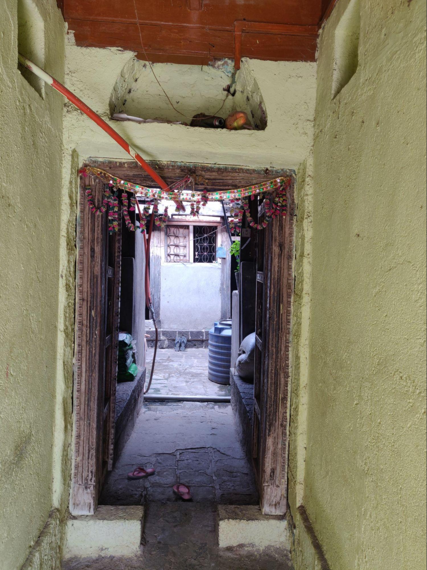 Main entrance opening into a narrow courtyard with stone-tiled flooring. (Source: CKA Archives)