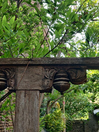 The backyard entrance features a wooden arch, with intricately carved decorative details at its corner. (Source: CKA Archive)