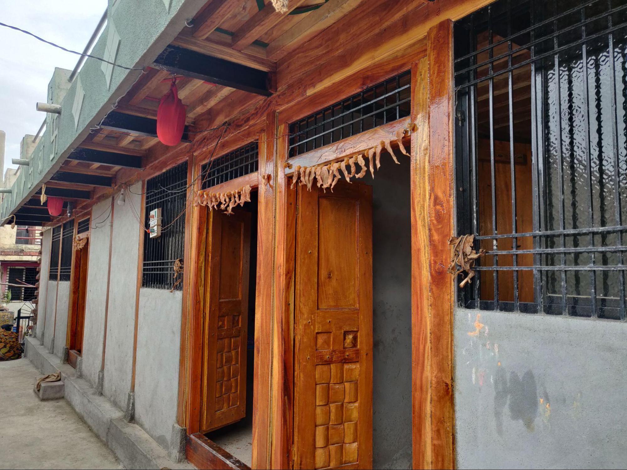 Windows with black metal grills and sliding glass panels, set in simple neem wood frames. (Source: CKA Archives)