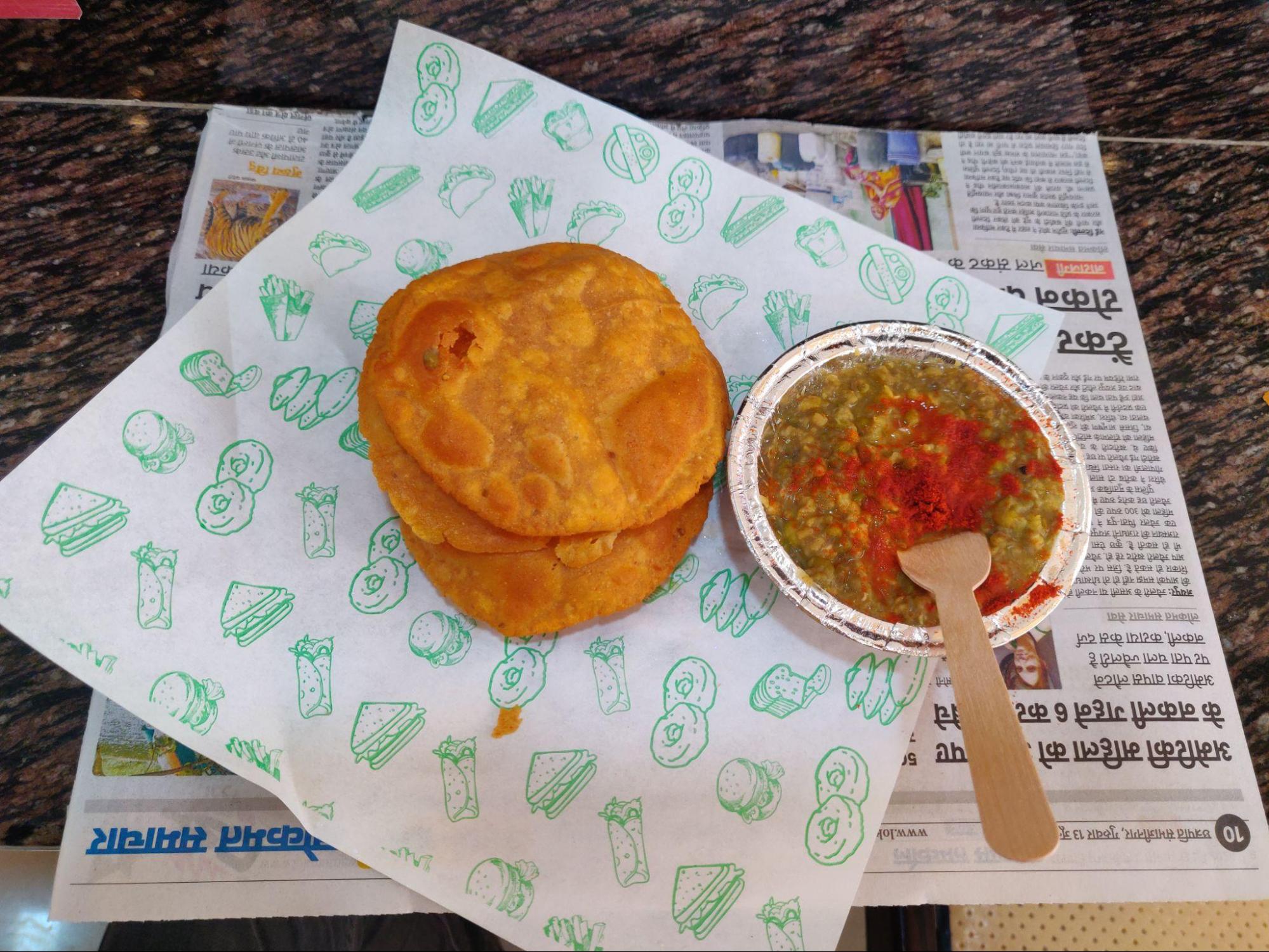 Moong Puri consists of a thick, creamy moong dal (yellow lentil) curry and puris (deep-fried puffed bread). The dal is typically prepared with a blend of spices, often including cumin, coriander, and red chili powder. This combination of flavorful dal and puris is a popular choice for breakfast or a light meal (Source: CKA Archives).