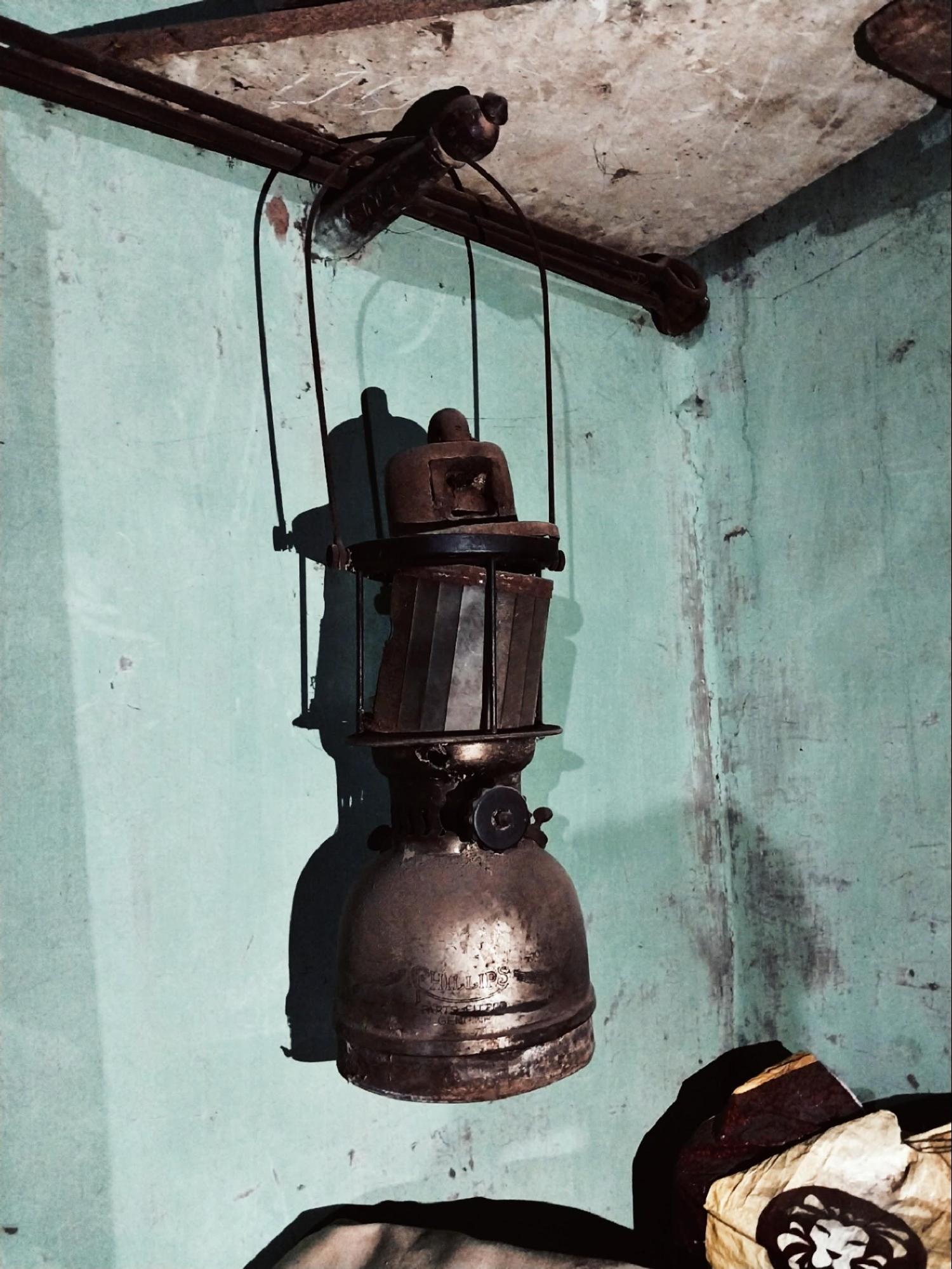 A vintage lampshade hanging from the ceiling, showcasing traditional lighting solutions used before electricity became commonplace. (Source: CKA Archives)