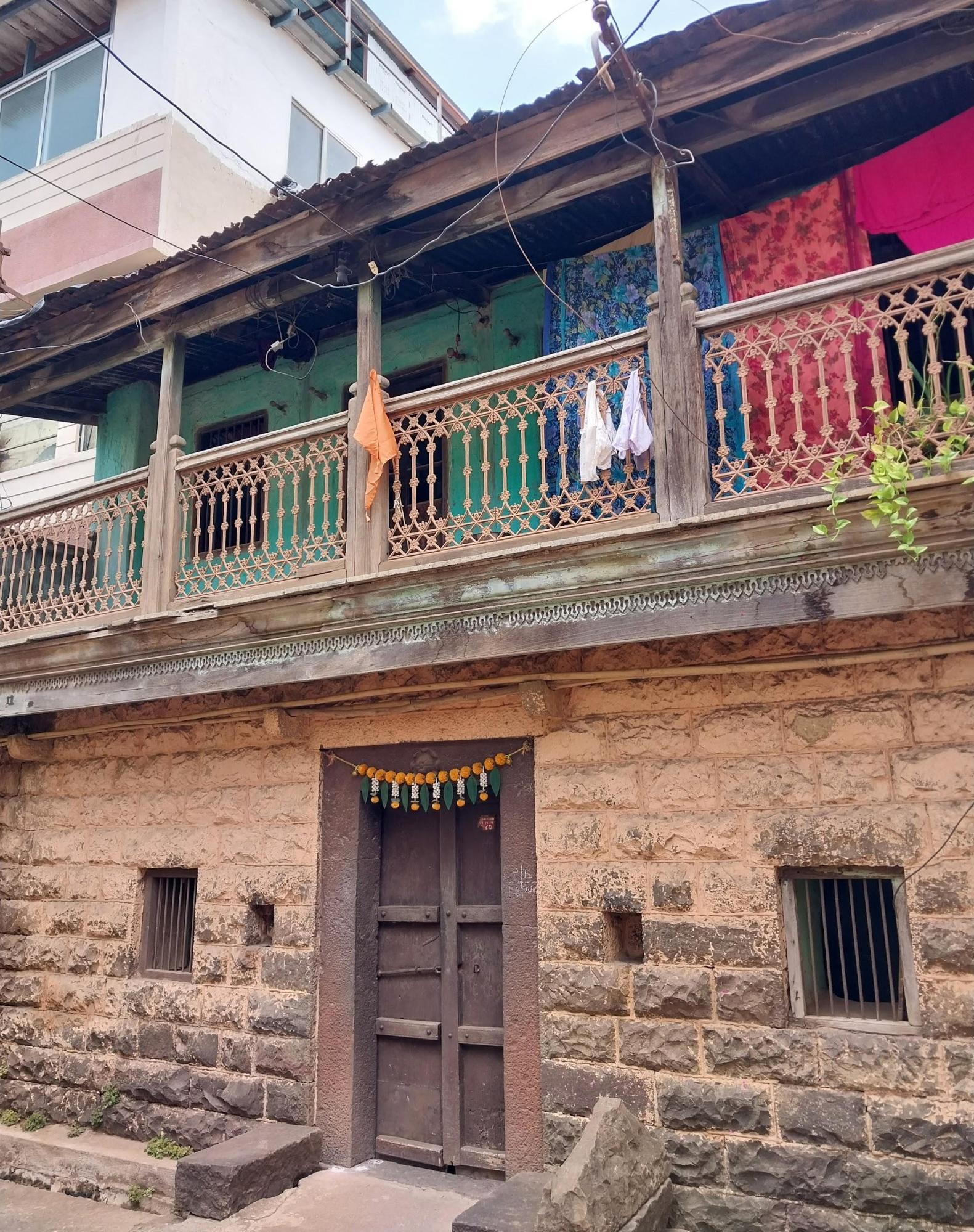 The devlis positioned beside the entrance door, traditionally used for placing oil lamps. Notice the overall color scheme of the house remains neutral, except for the balcony walls, which stand out in a distinct shade of green. (Source: CKA Archives)