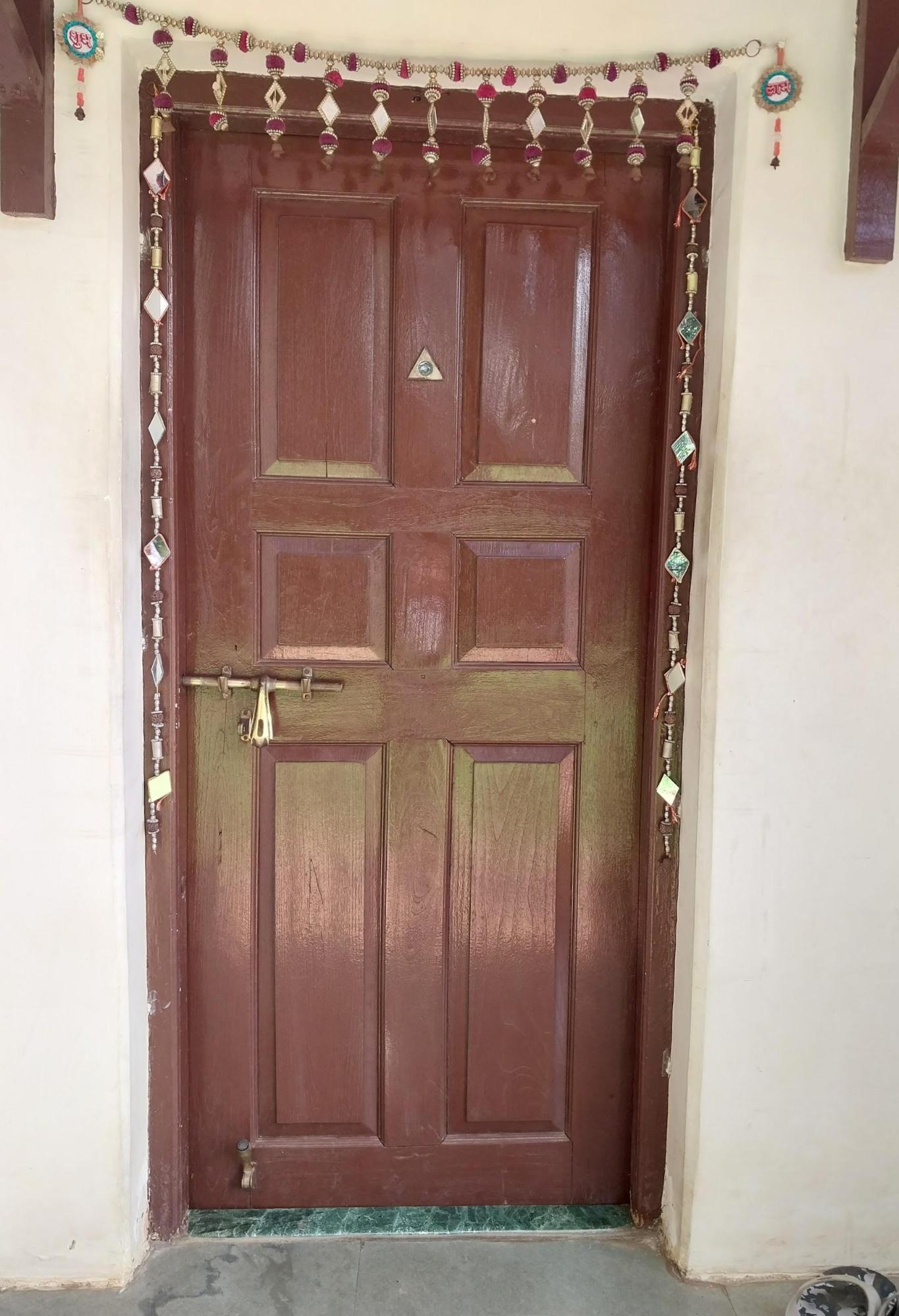 The main wooden entrance door includes a peephole for security and has an artificial toran above it. The torans here, in many ways, reflect a continuity in the practice adding cultural elements to personalize one’s home. (Source: CKA Archives)