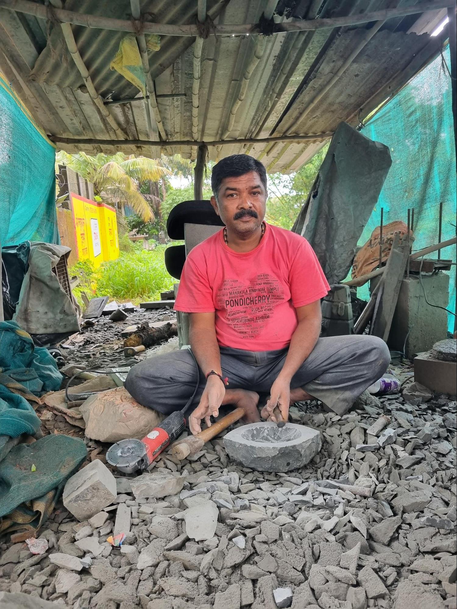 An artisan at work near the Khamgar Society Gate, shaping a traditional khalbatta, a small stone grinding tool still used in homes for preparing masalas and chutneys. Source: CKA Archives
