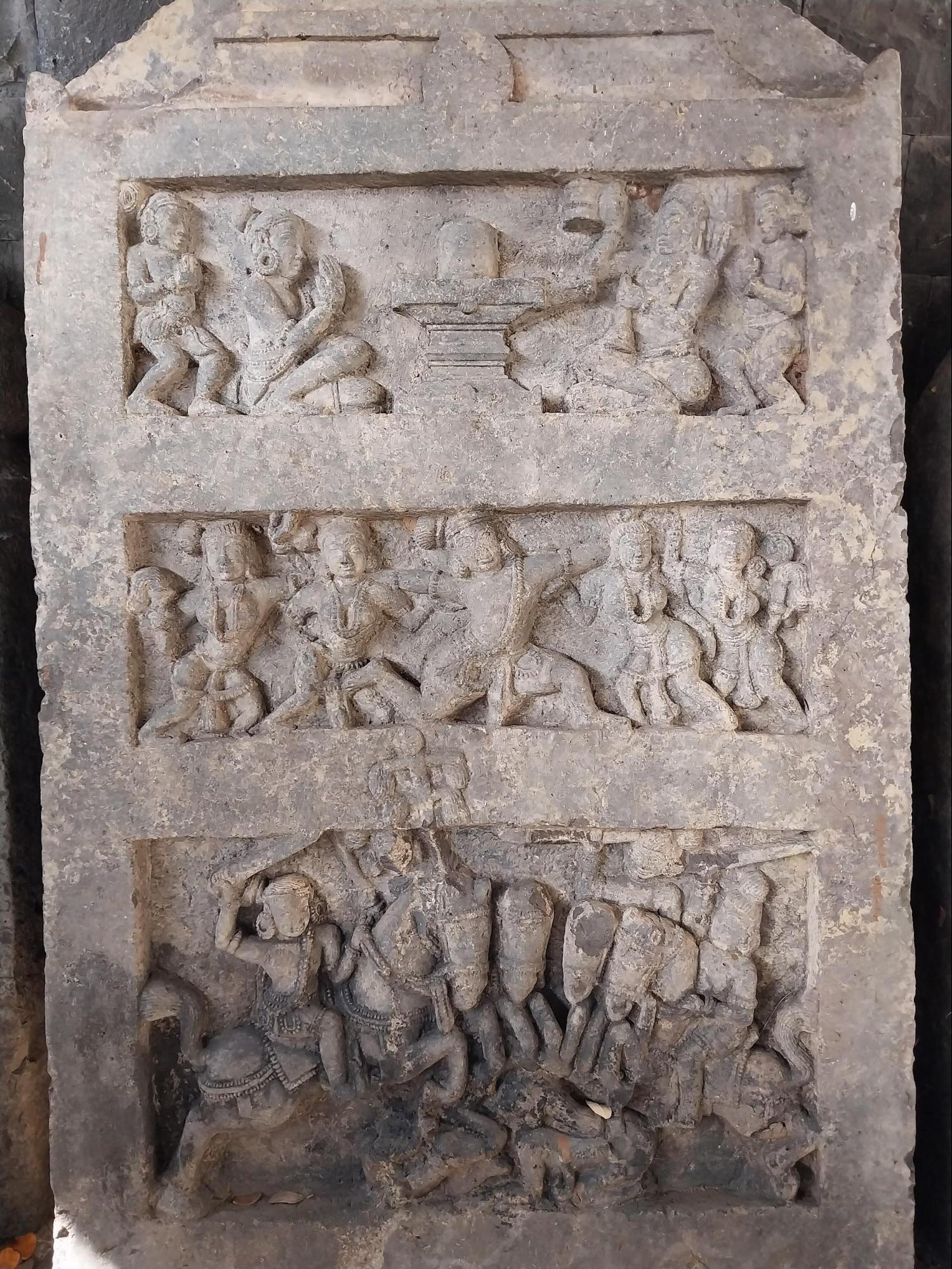 A stone carving depicting the heroic death of a warrior, his ascent to स्वर्ग (heaven) accompanied by celestial Apsaras such as Menaka, Urvashi, and Rambha, culminating in मोक्ष प्राप्ती (salvation) where he meets Mahadev. (Source: CKA Archives)
