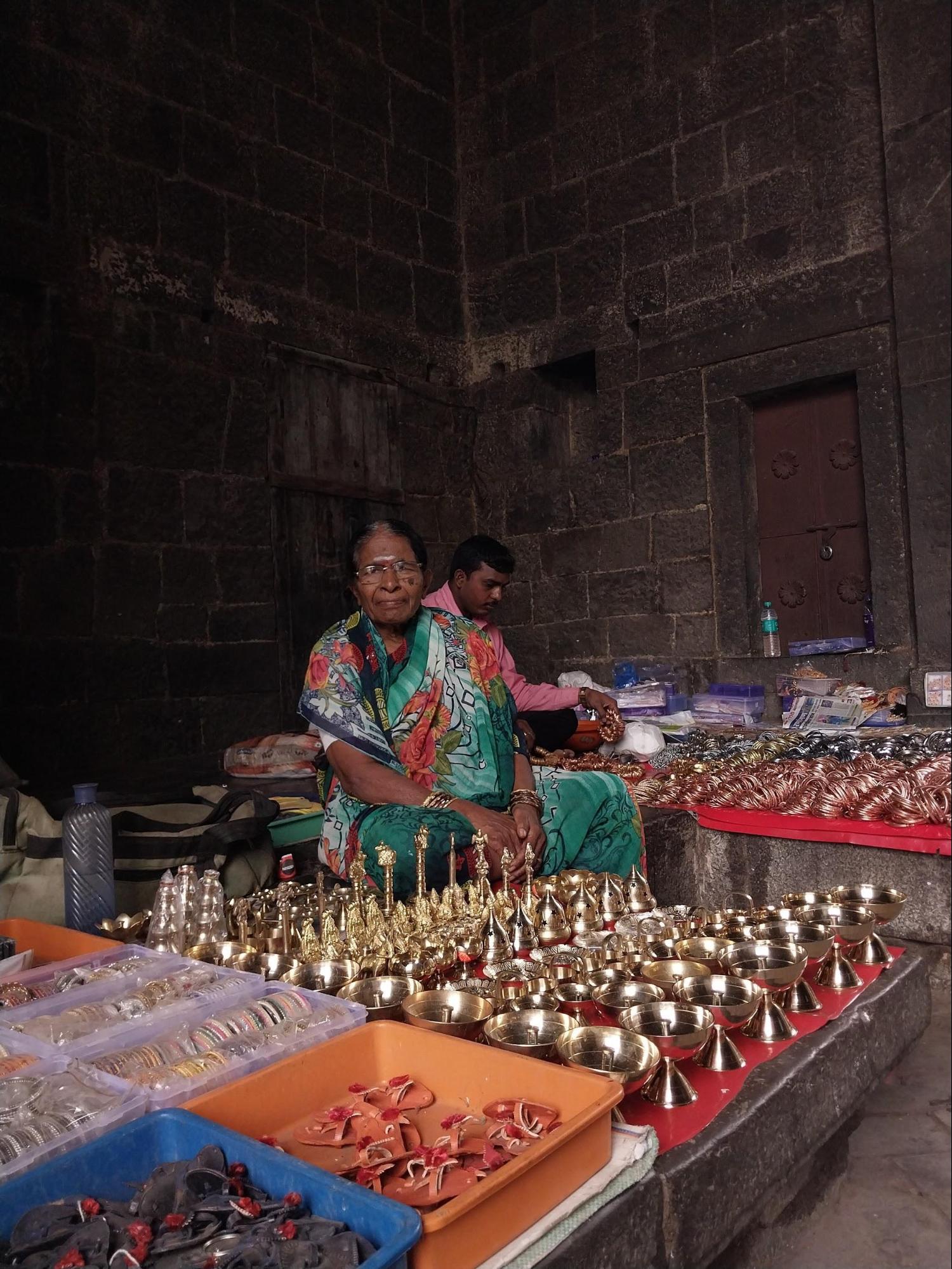A woman selling copper products inside the arch of Nagarkhana, bringing life to the historic space while showcasing Kolhapur's local crafts. (Source: CKA Archives)