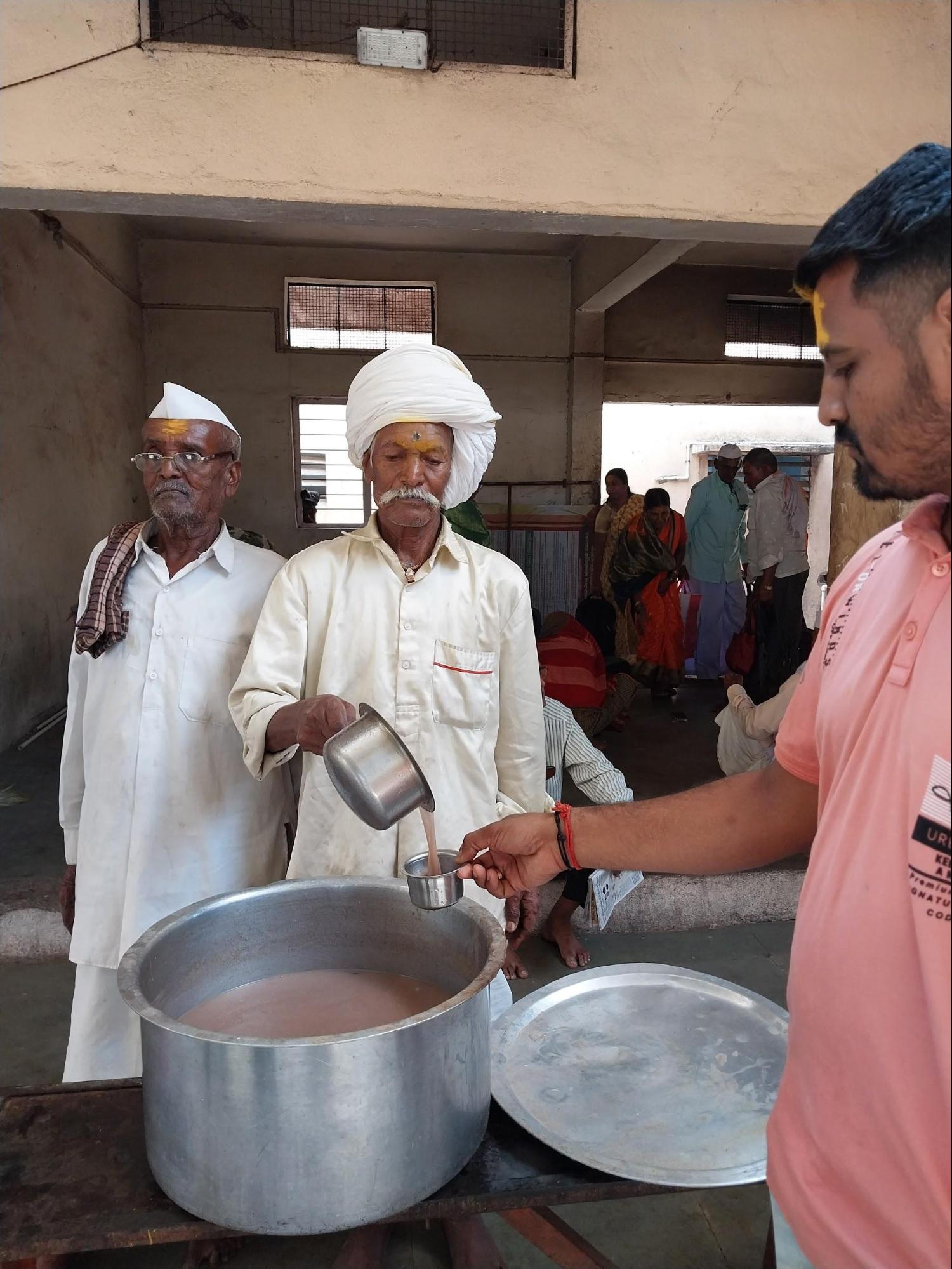 Traditional prasad, including Nachani Ambil, being distributed to devotees by the mandir committee.(Source: CKA Archives)