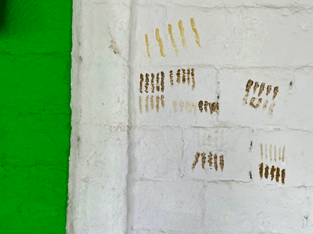 Wall of Pir Pasha Khadri Dargah marked with turmeric and henna fingerprints.This practice, followed by unmarried women seeking blessings before marriage, continues as part of local ritual tradition. (Source: CKA Archives)