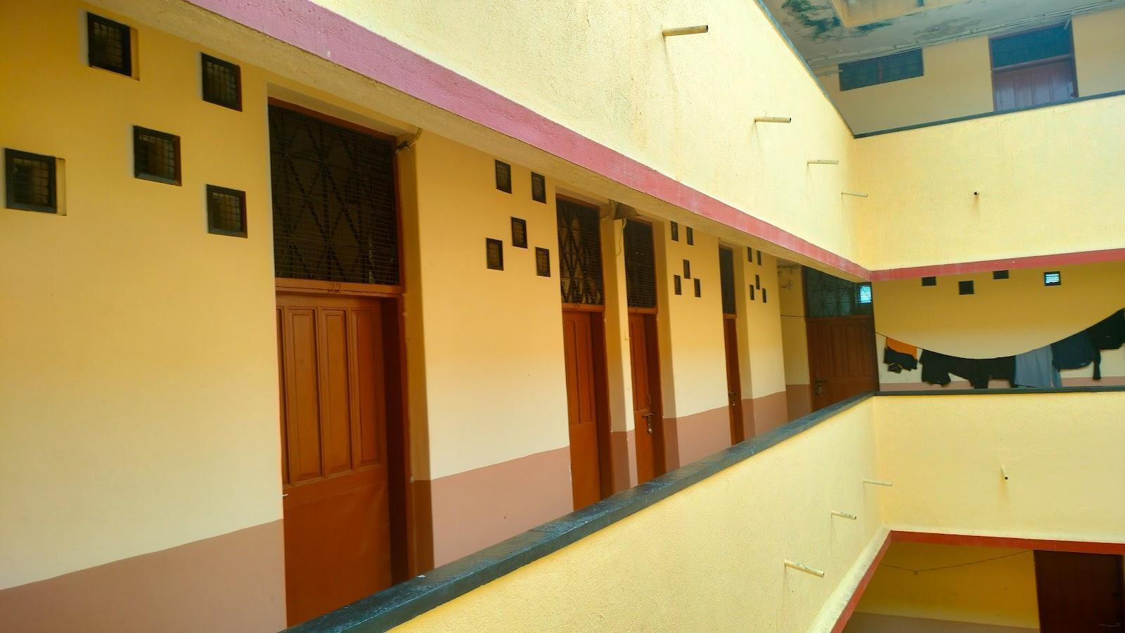 Common passageway connecting each room. The rooms have a wooden door with a window above the door having mild metal grills for ventilation. Source: CKA Archives