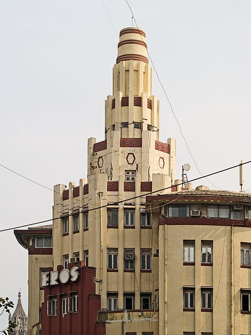 Vertical frames and horizontal red stone bands on the Cambata Building create a dynamic interplay—typical of Bombay’s Art Deco style.[18]