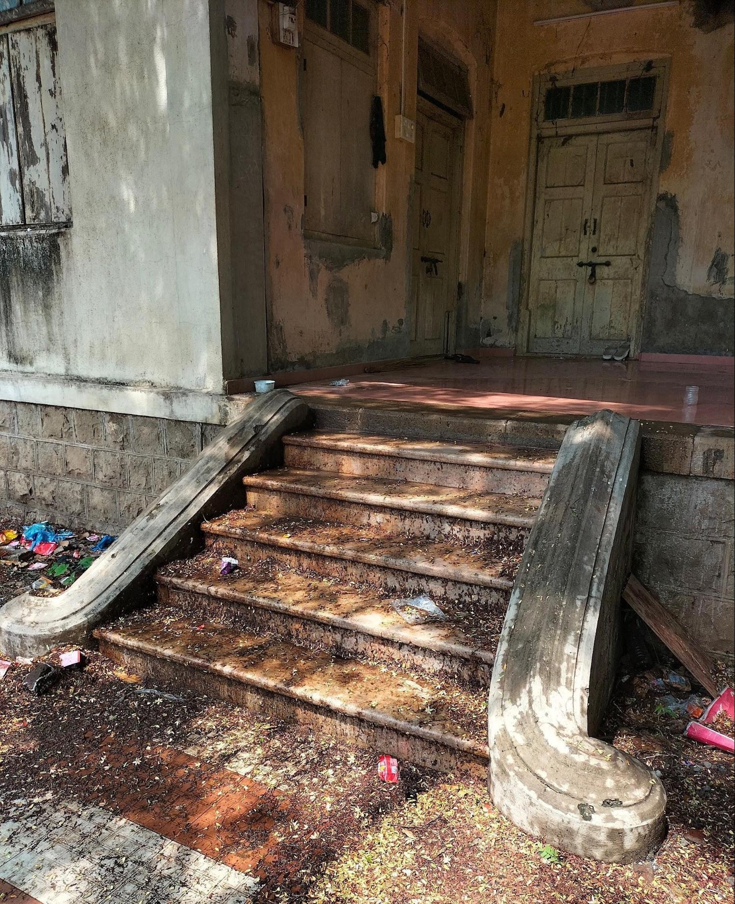 Stairs to the entrance of the house. The curved balustrade (sidewalls of the staircase) echoes the gentle flair of late colonial bungalow forms. (Source: CKA Archives)