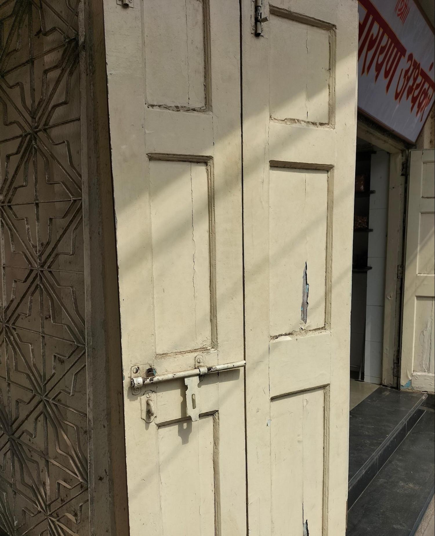 Wooden door with intricate grill designs attached at the entrance. This appears to be the main entrance to a big shop in the complex. Note the contrast in detailing between floors, and the consistency within each level. (Source: CKA Archives)
