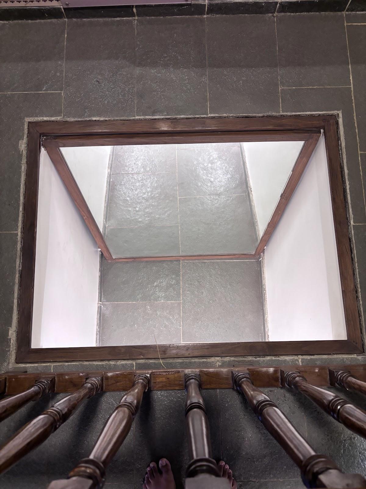 A concealed underground passage used by inhabitants of the wada to flee from the British enclosed by a wooden railing. (Source: CKA Archives)