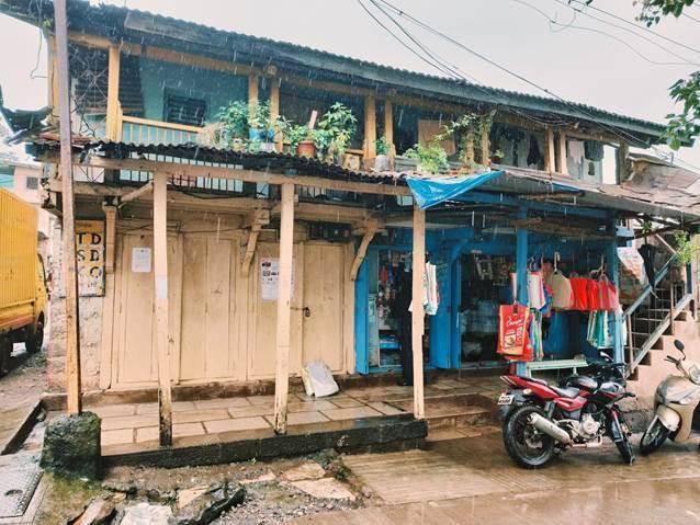 A neutral-colored wooden verandah with a pop of blue highlighting the convenience store. (Source: CKA Archives)
