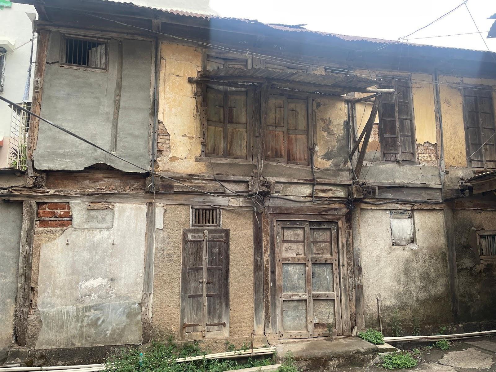 An old residence estimated to have been built in the 1860s, featuring a double-shuttered, panelled wooden door and small windows for ventilation. (Source: CKA Archives)