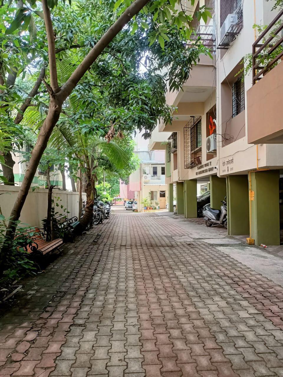 The interior of the residential society with a stone-tiled pathway in front of the building. (Source: CKA Archives)