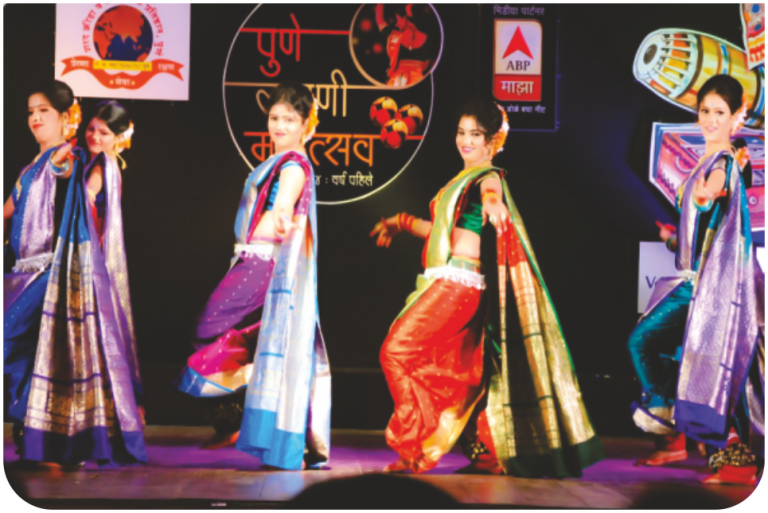 A group Lavani performance at Pune’s Lavani Mahotsav, featuring dancers in traditional nauvari sarees and ghungroos.[14]