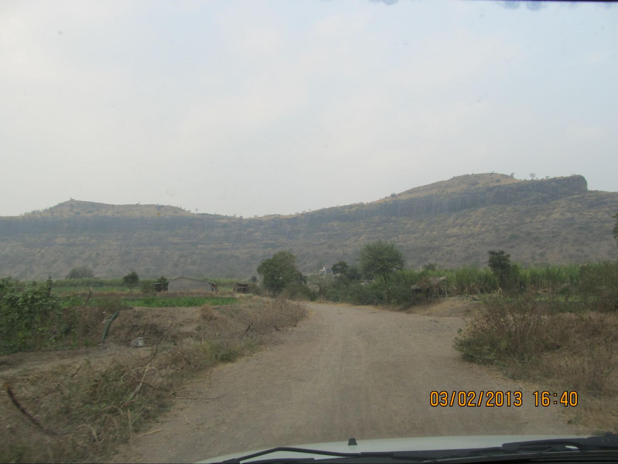 The winding path leading up to Narayangad Fort, flanked by rugged mountain terrain, offers a glimpse of the natural defenses that once made the fort nearly impenetrable. The fort itself may be hidden amidst the high peaks, but the surrounding landscape showcases its strategic positioning in the Maratha era. (Source: CKA Archives)