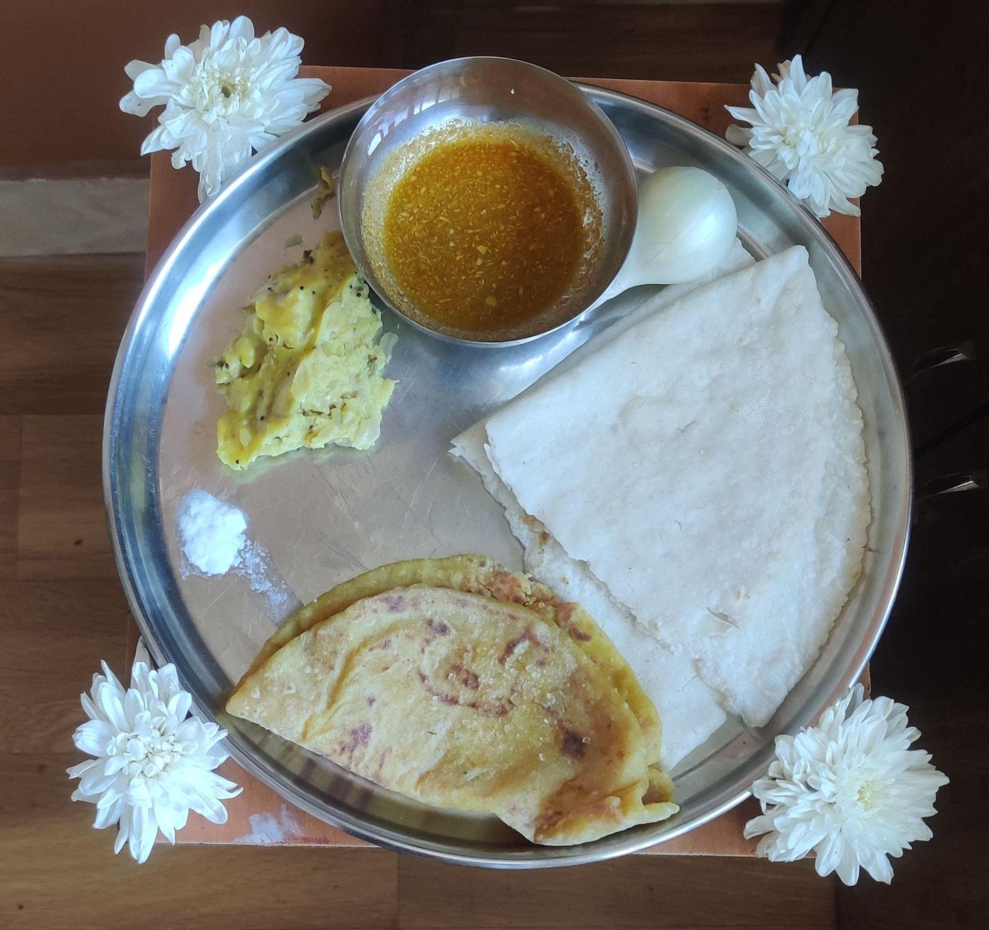 Home-cooked Vani meal on a special day: Rice bhakri, Puran Poli, Batatyachi Bhaaji, curry, and safed potato kanda (white onion). (Source: CKA Archives)