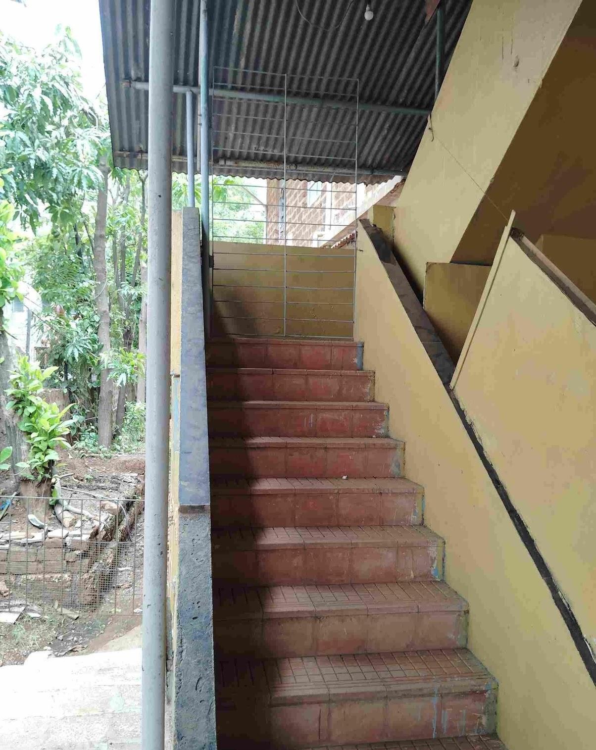 Inner staircase of the house with cement steps finished in mud tiles and a cement railing. (Source: CKA Archives)