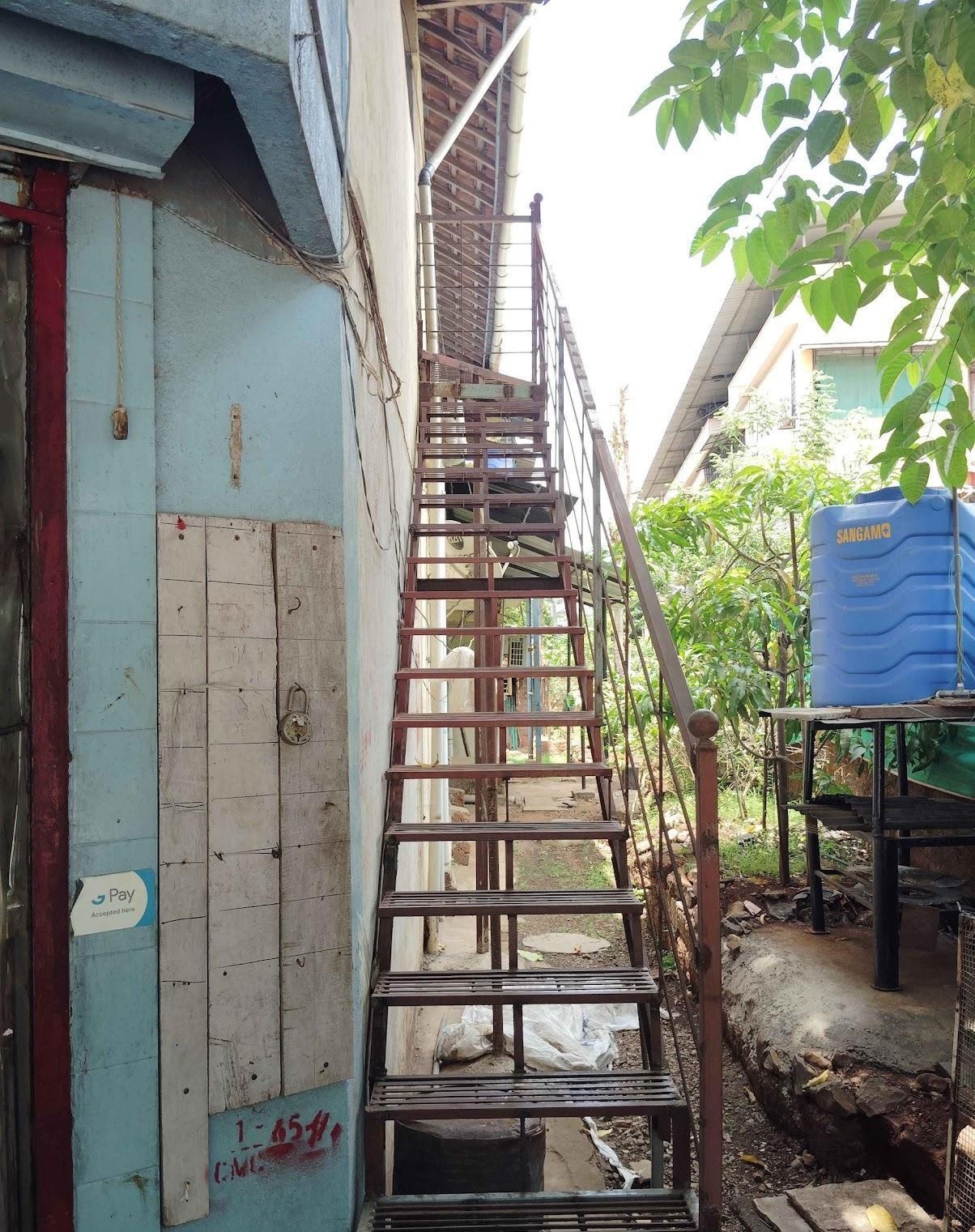 Iron staircase on the exterior of the house with a matching iron railing, leading to the upper storey. (Source: CKA Archives)