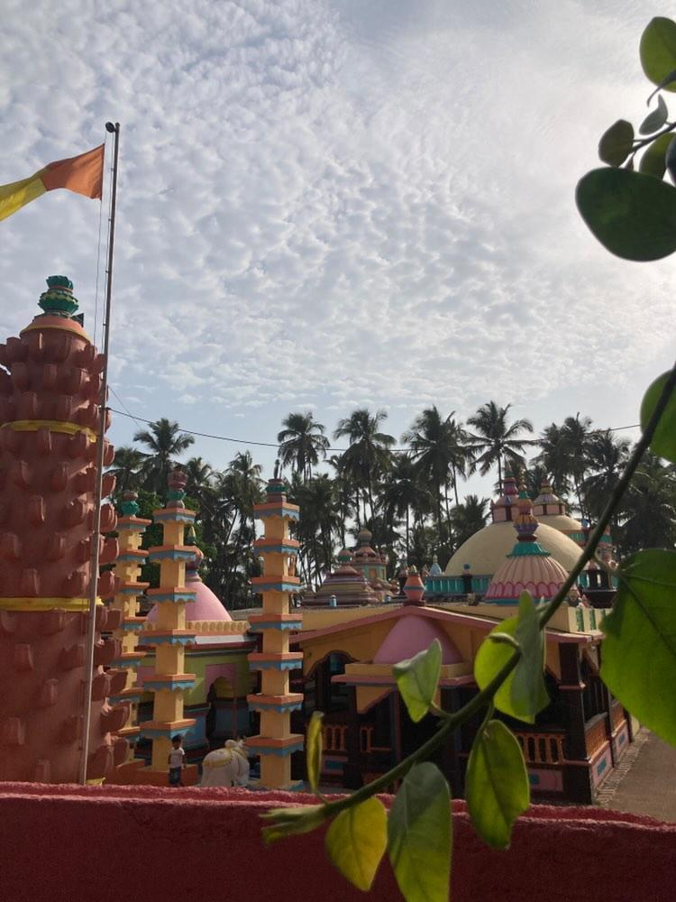 Multiple pillars and deepmals (stone lamp towers) are arranged around the Velneshwar Mandir, each adorned with distinct, bright colours. (Source: CKA Archives)