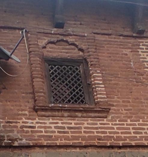 Arched brick-framed windows with iron jalis. The placement aligns with the building’s symmetrical front facade. (Source: CKA Archives)
