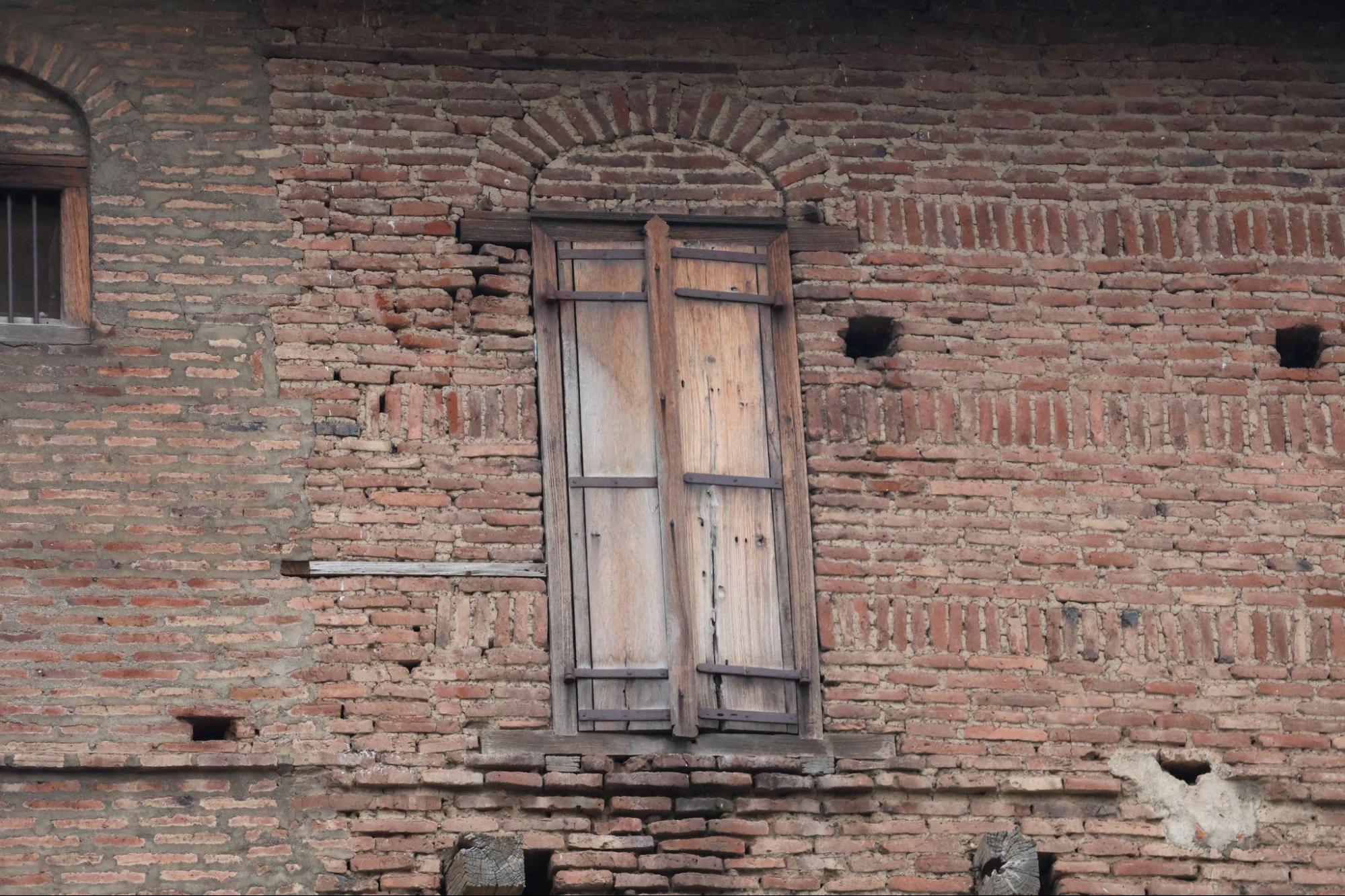 Close view of arched brick window and wooden shutters. Notice the intricate brick masonry within which the windows are set.(Source: CKA Archives)