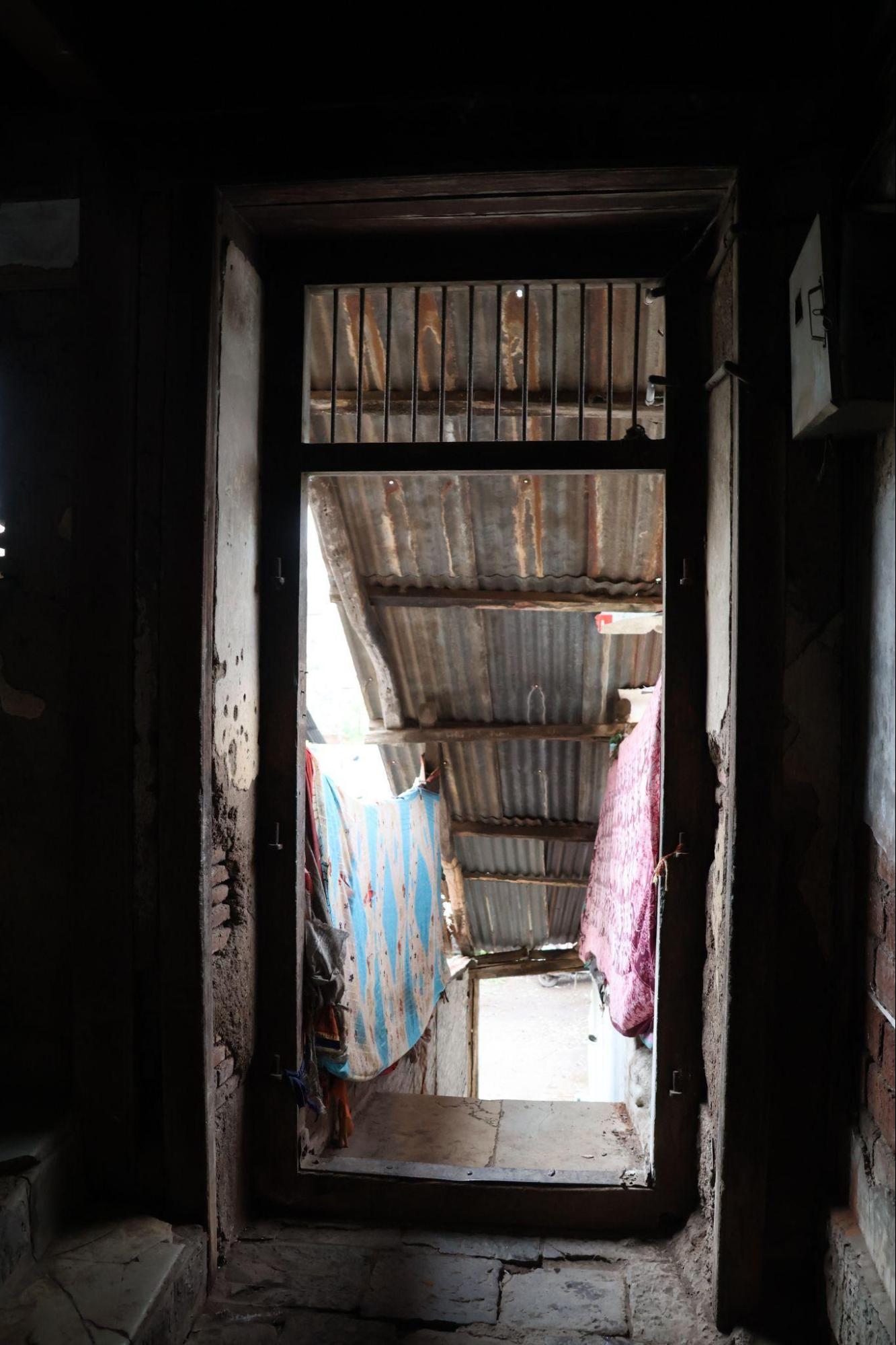 Rear access stairway leading to the residential level. The area is used informally for drying and storage.(Source: CKA Archives)